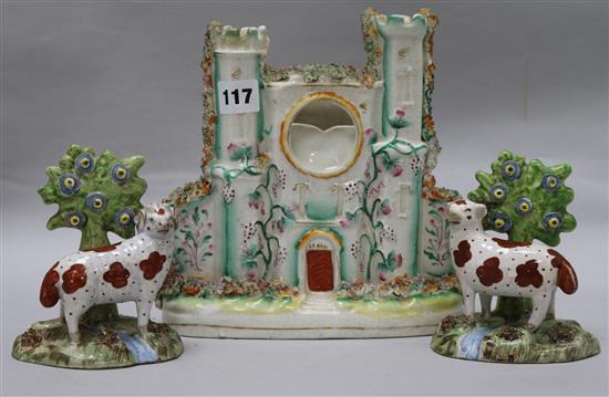 A pair of staffordshire cows and a castle flatback tallest 23cm